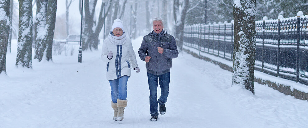 Mature Couple Jogging In Snow